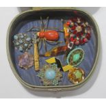 A small quantity of vintage costume brooches including a brooch formed as a golf bag and clubs, a