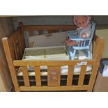 A dolls cot and contents comprising a Michelle doll in high chair and a vintage porcelain doll in