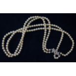 A two strand cultured pearl necklace with white metal diamond set clasp marked '9c', pearls
