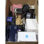 A box of mixed camera items including various lenses.