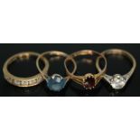 A group of three hallmarked 9ct gold rings including one set with a garnet, together with another
