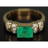 An emerald and diamond ring, the central stone weighing approx. 1.34 carats, band marked '750',
