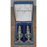 A pair of Bloomingdales pepper pots marked 'Empire Sterling Weighted', height 12cm, with box.