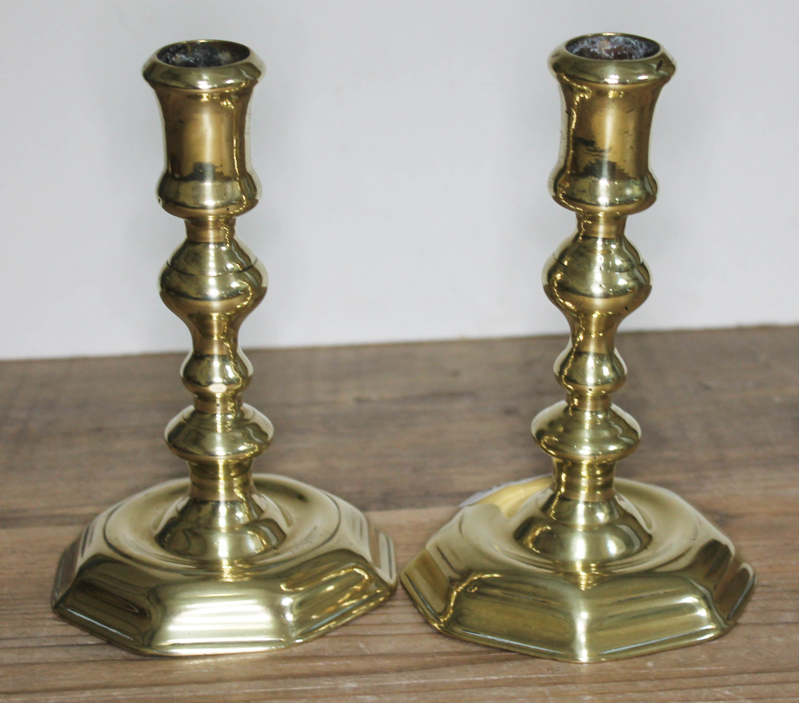 A pair brass candlesticks, heights 17cm. Condition: dents to both sticks.
