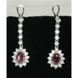 A pair of ruby and diamond drop earrings, each pear cut ruby weighing approx. 0.88ct, total