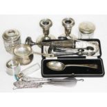 A mixed lot of hallmarked silver including sugar tongs, candlesticks, scent bottles etc.