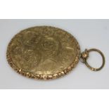 A Victorian gilt metal photo locket of oval form, the exterior with engraved scrolls, 50mm x 78mm,