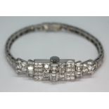 An Art Deco diamond encrusted cocktail bracelet watch, the baguette and modern round brilliant cut