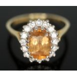 A citrine and diamond cluster ring, the central stone measuring approx. 8mm x 5mm x 2mm, surrouned