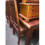 An Indian hardwood dining table with six high back chairs with studded leather padded seats.
