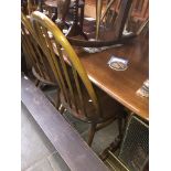 An Ercol oak and beech table and six spindle back chairs inc two carvers Catalogue only, live