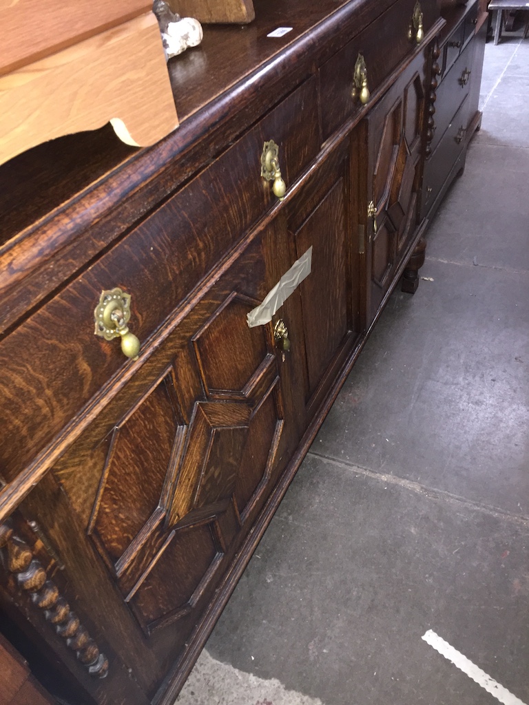 An oak sideboard with rail back, brass tear drop handles and geometric door panels Catalogue only,