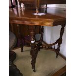 An Edwardian octagonal table with turned legs, finial stretchers and ceramic castors Catalogue only,