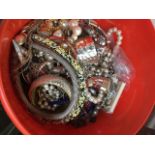 A red tub of costume jewellery. The-saleroom.com showing catalogue only, live bidding available