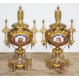 A pair of ormolu and porcelain urns, architectural style with finials, handles and bows, each with a