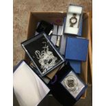 A box of boxed watches and costume jewellery.