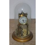 A brass revolving pendulum clock under glass dome, dial diam. 8cm, height of dome approx. 32cm.