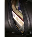 A hard case wheelie suitcase with books. Catalogue only, live bidding available via our website,