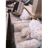 A four piece cream and floral patterned cloth suite including pair of armchairs, 3 seater sofa and