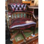 A reproduction oxblood buttoned and studded leather swivel captains chair Please note, lots 1-1000
