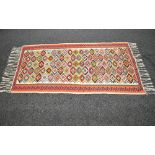 Cream ground rug with blue, orange, brown and mustard pattern with end tassels - 36.