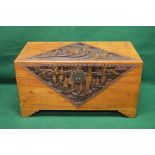 Heavily carved camphor wood chest opening to reveal storage space,