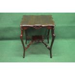 Edwardian walnut two tier occasional table having shaped top over carved frieze,