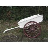 Wood and iron hand cart with leaf springs and 3' dia wheels, finished in white with burgundy wheels.