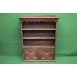 Oak bookcase the top having moulded edge with a raised back over a shaped frieze and two fixed