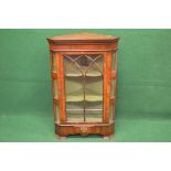 Mahogany free standing glazed corner cabinet having glazed door opening to reveal green painted