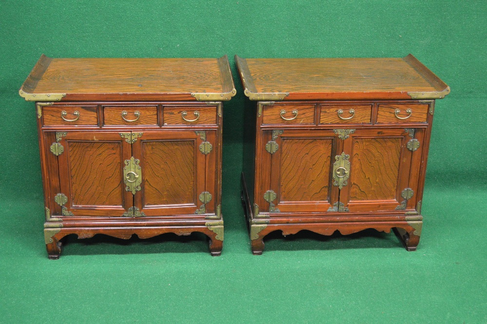 Pair of 20th century Chinese style side cabinets having brass bound corners the tops having raised