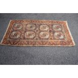 Brown ground rug having cream and blue pattern with end tassels - 76" x 40.