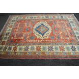 Red ground rug having blue, red and cream pattern with end tassels - 121.