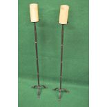 Pair of floor standing iron candle sconces supported on triformed stands with flat feet - 34.