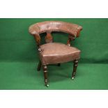 Oak captains tub chair having buttoned leather back supported on carved oak uprights leading to