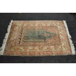 Green ground rug having pink, green, red and brown pattern with end tassels - 74" x 47.