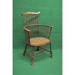 Beech framed comb back Windsor chair having cane seat and supported on turned stretchered legs
