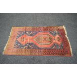 Red ground rug having blue, brown and cream pattern with end tassels - 66" x 36.