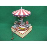 Bespoke wooden model of a carousel with six suspended aeroplanes or chairs.