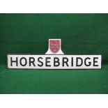 Embossed enamel road side village sign for Horsebridge with black frame and pole brackets