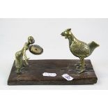 Asian brass figure of man with large bird on wooden base