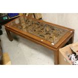 South East Asian Hardwood Coffee Table, the glass covered panel to top heavily carved with a scene