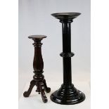 A black painted torchere with reeded support, one other similar raised on three legs & a brass