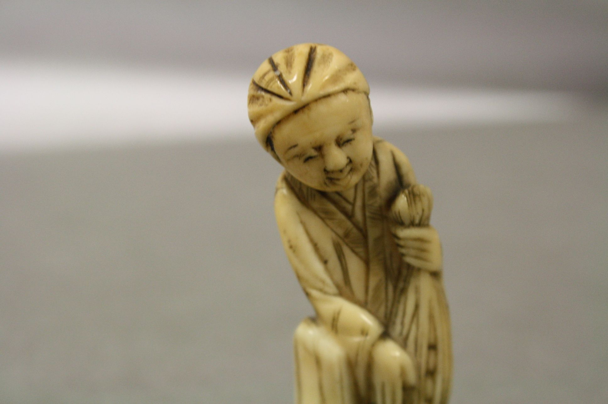 Antique ivory netsuke in the form of a man with net - Image 2 of 3