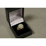 Diamond three tier yellow metal cluster ring, the central round brilliant cut diamond weighing