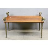 Cherry wood coffee table with brass legs and topped with goat heads