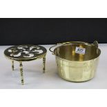 A vintage brass preserve pan and a three legged trivet with pierced decoration