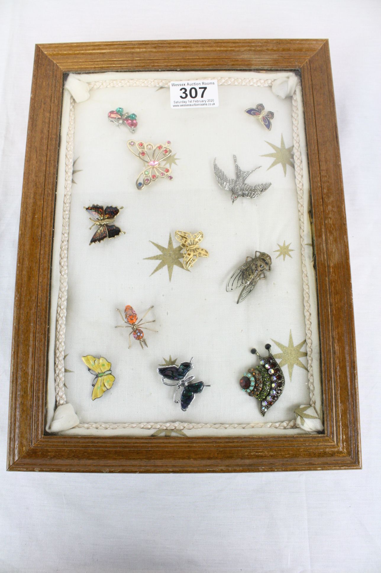 Display case containing vintage and modern brooches including silver & enamel butterfly, bird, bee,