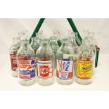 19 vintage advertising milk bottles, together with bottle carrier