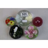 Five glass paperweights, to include a Caithness decorated with daisy flowers, etched to base